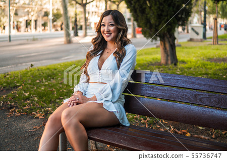 Beautiful Asian girl in white dress smiling in the park 55736747