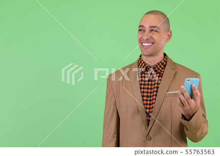 Happy bald multi ethnic businessman thinking while using phone Happy bald multi ethnic businessman thinking while using phone 55763563
