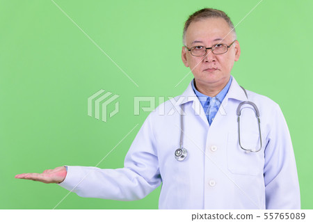 Mature Japanese man doctor with eyeglasses showing something Mature Japanese man doctor with eyeglasses showing something 55765089