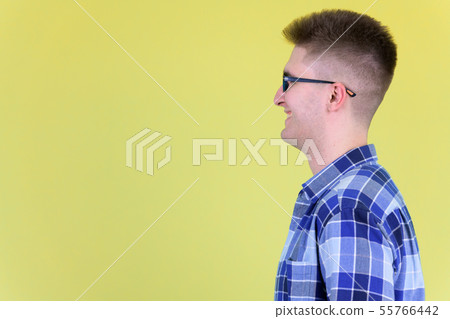 Profile view of happy young hipster man smiling Profile view of happy young hipster man smiling 55766442