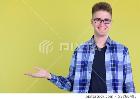 Happy young handsome hipster man showing something Happy young handsome hipster man showing something 55766493