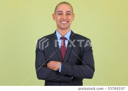 Happy bald multi ethnic businessman smiling with arms crossed Happy bald multi ethnic businessman smiling with arms crossed 55769197