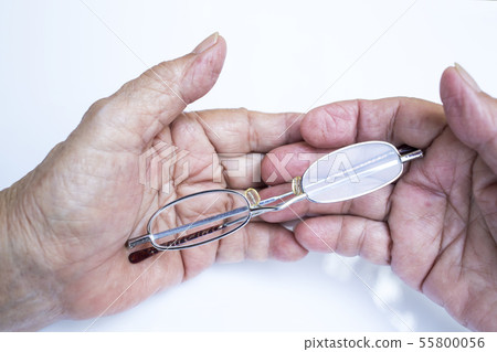 Old woman hands holding longsighted eye glasses   55800056