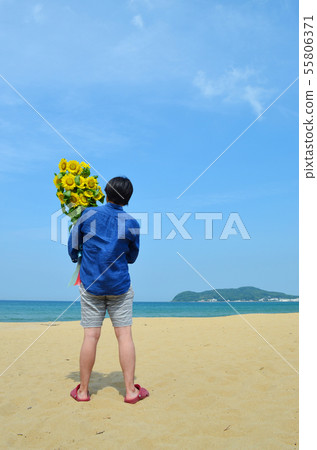 A man with a bouquet of sunflowers on the beach A man with a bouquet of sunflowers on the beach 55806371