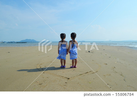 Twin girls back view on beach heart Twin girls back view on beach heart 55806784