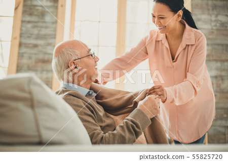 Kind smiling woman covering her ward with warm plaid 55825720