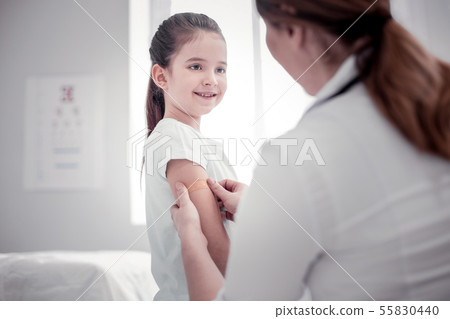 Pleasant nice young woman putting a plaster 55830440