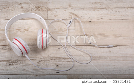 The white headphones are red on the wood floor. 55831481