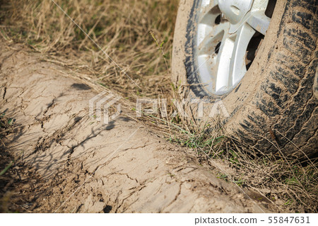 Dirty car wheel is on wet rural roadside Dirty car wheel is on wet rural roadside 55847631