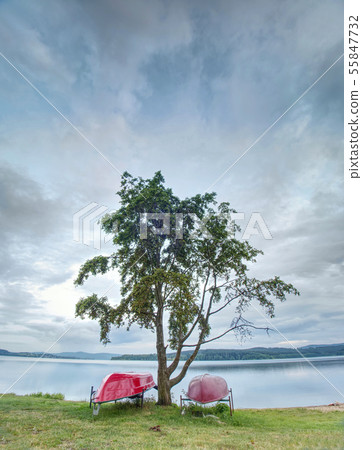 Simple rowing boat stacked at lake upside down. 55847732