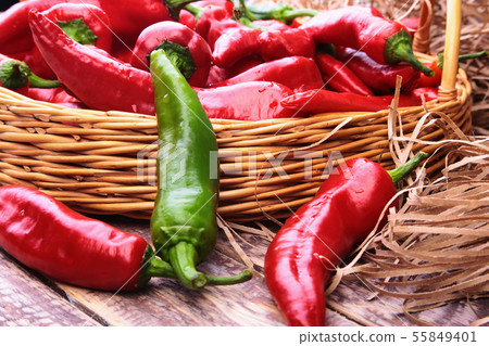 Wicker basket full of fresh red chili peppers. Wicker basket full of fresh red chili peppers. 55849401