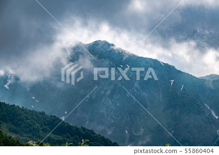 High rocky mountain peak in the clouds. 55860404