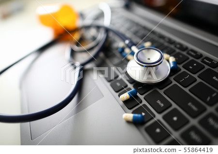 Stethoscope head with scattered tablets on 55864419