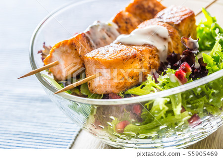 Grilled salmon skewers with summer lettuce salad 55905469