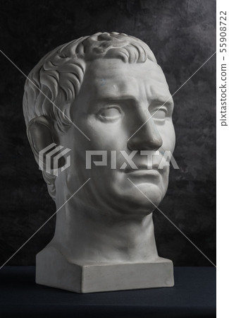 Gypsum copy of ancient statue Augustus head on dark textured background. Plaster sculpture man face. Gypsum copy of ancient statue Augustus head on dark textured background. Plaster sculpture man face. 55908722