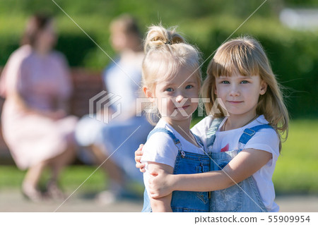 Two girls became friends and embraced while their Two girls became friends and embraced while their 55909954