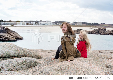 the sisters are sitting on the shore of the ocean the sisters are sitting on the shore of the ocean 55910080