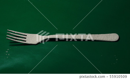 Cutlery fork sprinkled with white flour 55910509
