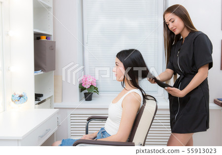 hairdresser examines client's hair hairdresser examines client's hair 55913023