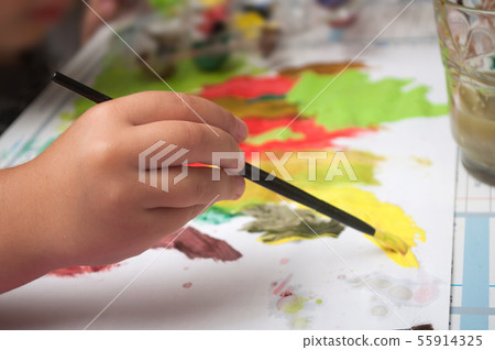 Closeup of hand of child painting on paper Closeup of hand of child painting on paper 55914325