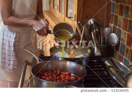 Pan with caramelised tomatoes cherry process of cooking and adding ingredients hands 55916095