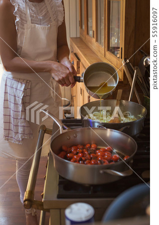 Pan with caramelised tomatoes cherry process of cooking and adding ingredients hands 55916097