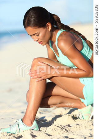 Runner leg injury - Asian running woman with hurting knee pain 55918838