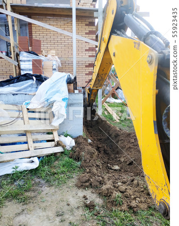 The excavator digging a trench near a cable house The excavator digging a trench near a cable house 55923435