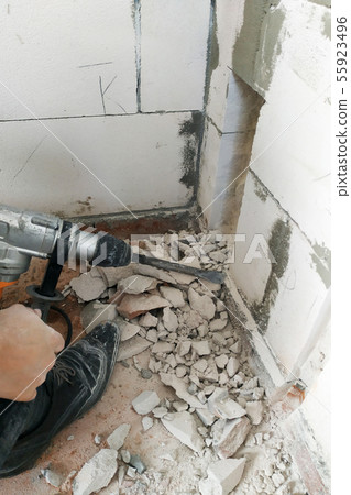 A worker with a perforator breaks the wall and 55923496