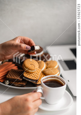 Woman snacking with sweets and junk food Woman snacking with sweets and junk food 55923723