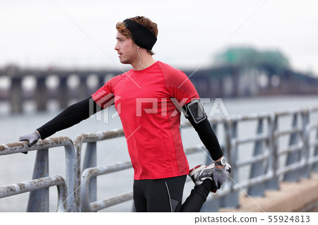 Male runner training in cold winter doing warm-up 55924813