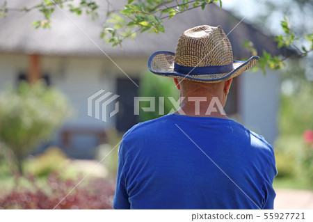 adult man hat tree village background 55927721