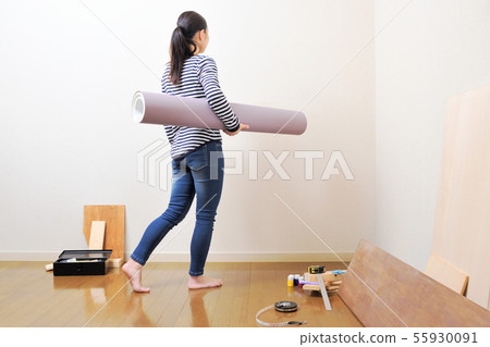 DIY woman putting a wallpaper 55930091