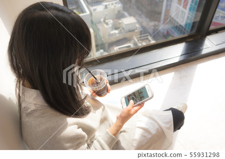 放鬆在咖啡館的婦女使用與智能手機 55931298