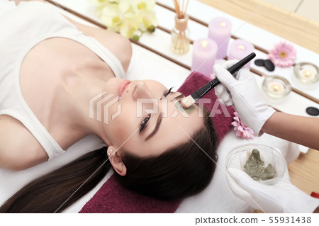 Girl with facial mask lying in beauty health spa center 55931438