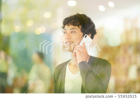 A young man talking on a smartphone A young man talking on a smartphone 55932015