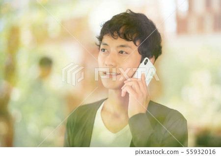 A young man talking on a smartphone A young man talking on a smartphone 55932016