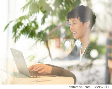 Young man operating a laptop 55932017