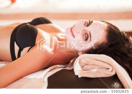 Spa mask. Beautiful woman get spa mask on the sunny beach in spa salon outdoor. High quality. Scin 55932655