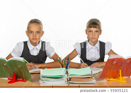 Two schoolgirls gaze intently and emotionlessly 55935121