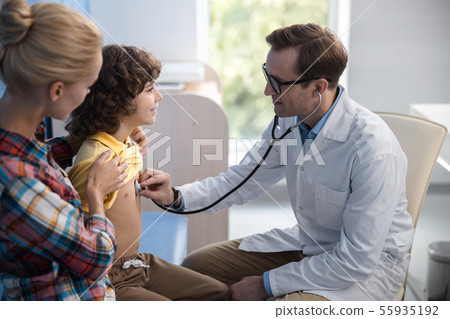 Smiling kid is seeing physician with mother stock photo Smiling kid is seeing physician with mother stock photo 55935192