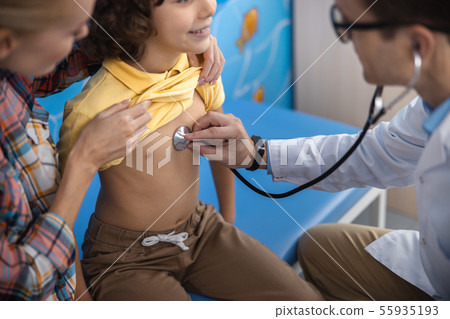 Practitioner is examining child with stethoscope stock photo Practitioner is examining child with stethoscope stock photo 55935193