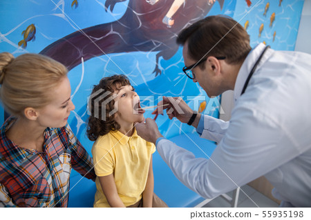 Boy is having throat checked up stock photo 55935198