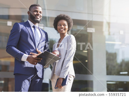 Two african american colleagues standing outdoors and looking aside 55935721