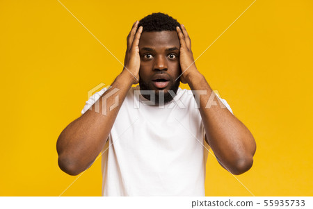 Shocked african american man holding hands on his head Shocked african american man holding hands on his head 55935733