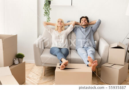 Joyful Husband And Wife Relaxing On Couch In New Home Joyful Husband And Wife Relaxing On Couch In New Home 55935887