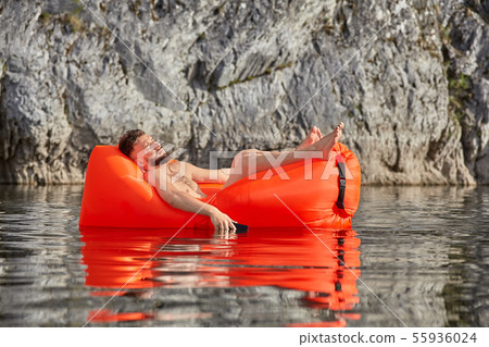 Caucasian man sleeps on airsofa with phone. Caucasian man sleeps on airsofa with phone. 55936024