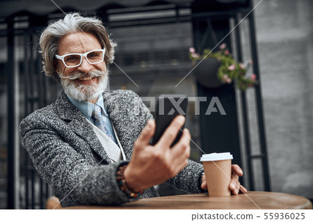 Happy mature gentleman with smartphone stock photo Happy mature gentleman with smartphone stock photo 55936025