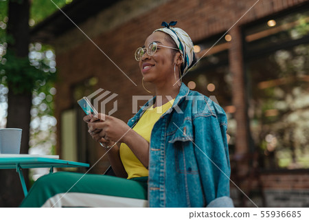 Young african american female holding mobile phone 55936685