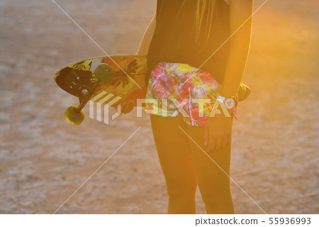 Teen with skate at sunset. Teen with skate at sunset. 55936993